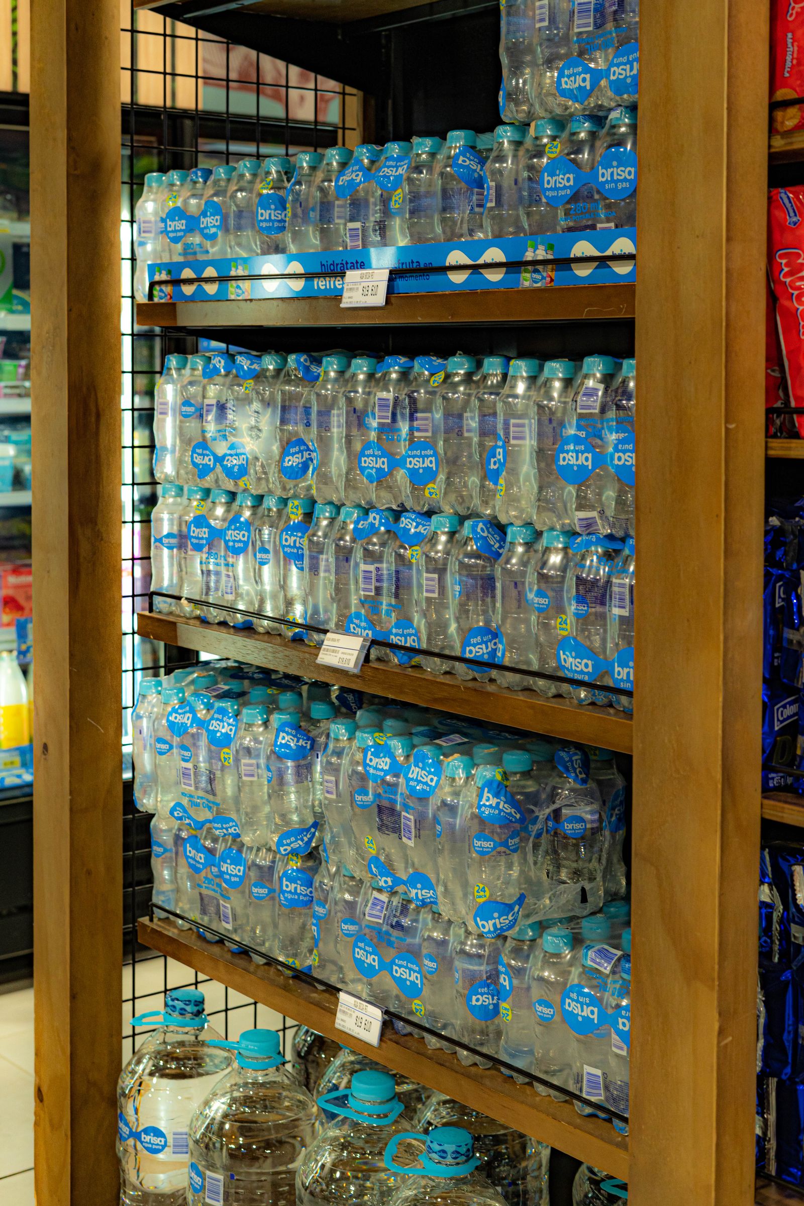 Botellas de jugo ordenadas en anaqueles de supermercado