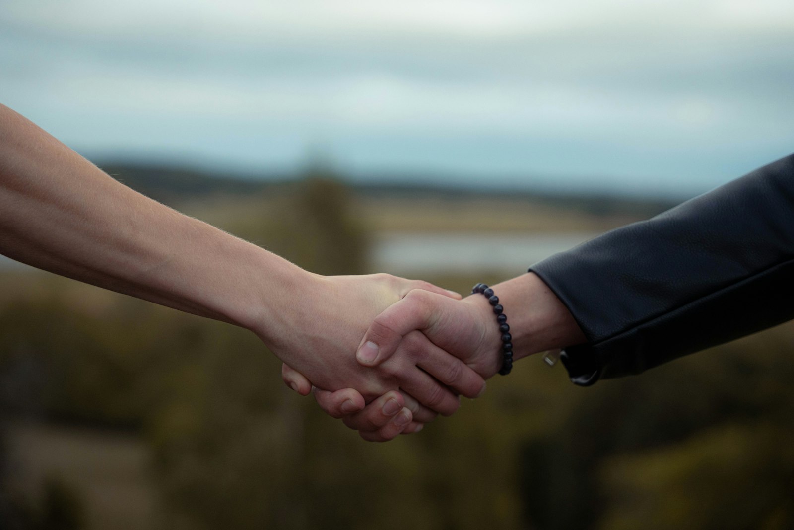 Dos personas dándose la mano en un gesto de confianza