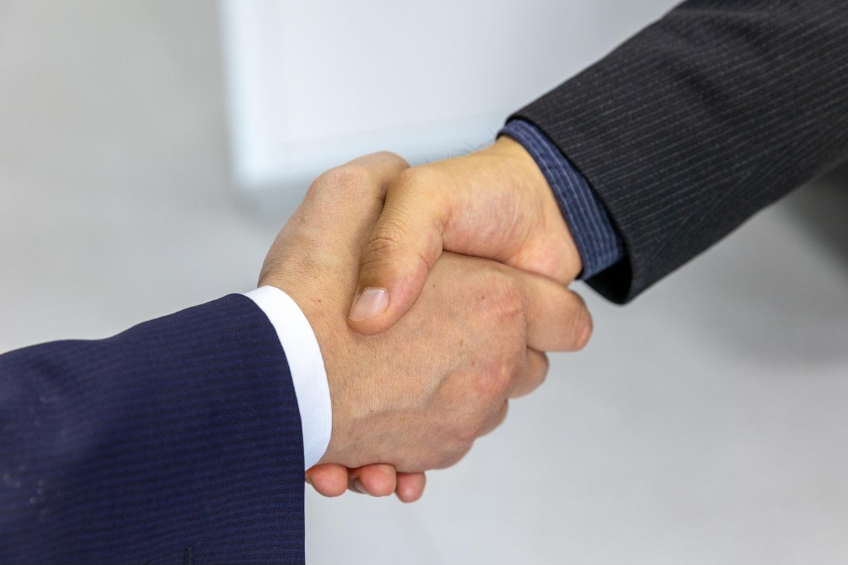 Dos personas dándose la mano en una negociación de negocios
